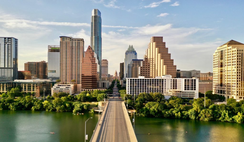 he towering skyline of Austin, Texas as seen from over a bridge
