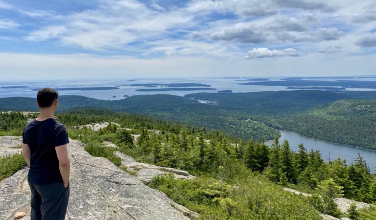 Nomadic Matt posing for a photo while hiking in Maine