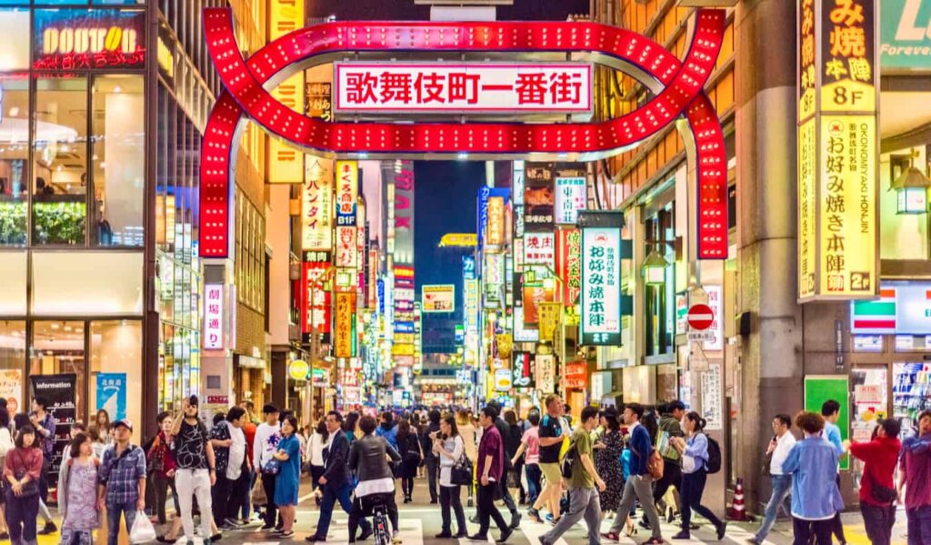 A huge crowd of people crossing the street in bustling Tokyo, Japan at night